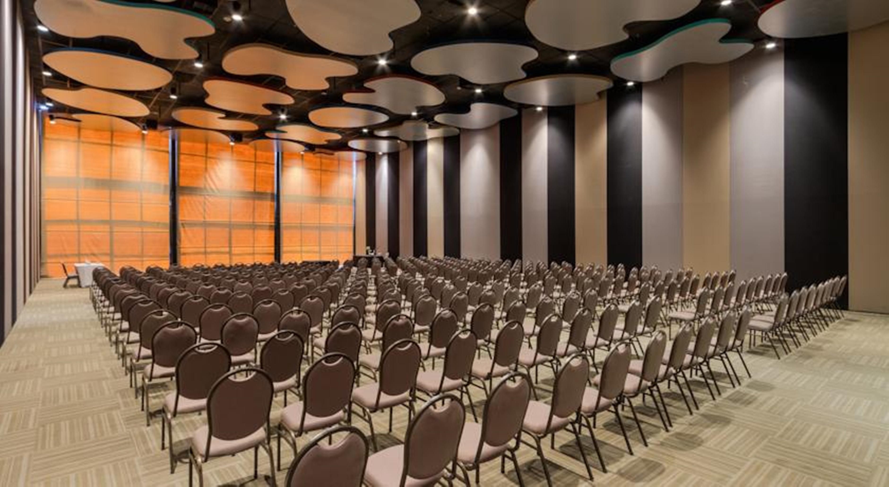 Royal Tulip Brasilia Alvorada Hotel Exterior foto The photo shows a large conference or event space filled with numerous empty chairs arranged in rows. The chairs have a simple design, with cushioned seats and backs. The walls of the room are decorated with a combination of dark and light tones, and